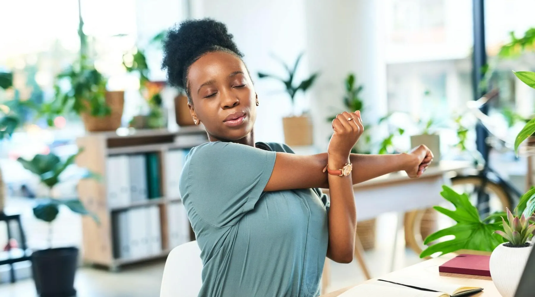 Employee performing seated stretch at workstation